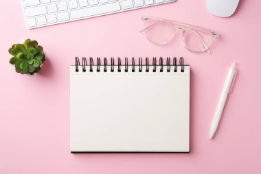 Not defteri, kalem, gözlük, çiçek dekoru, pembe arka planda bilgisayar klavyesi ve fare, düz konum