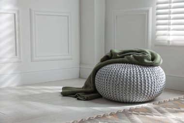 Evde ekose örülmüş şık bir pouf. Metin için boşluk