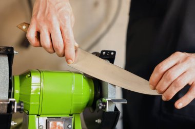 Bıçak keskinleştiren adam içeride, yakın plan.