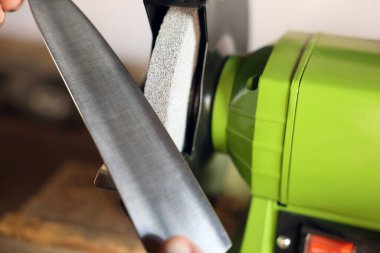 Bıçak keskinleştiren adam içeride, yakın plan.