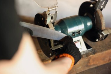 Bıçak keskinleştiren adam içeride, yakın plan.