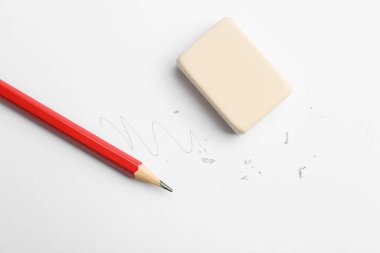 Beyaz arka planda kalem, silgi, karalama ve kırıntılar, düz uzanma