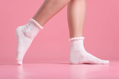 Pembe arka planda beyaz çoraplı kadın, yakın plan.