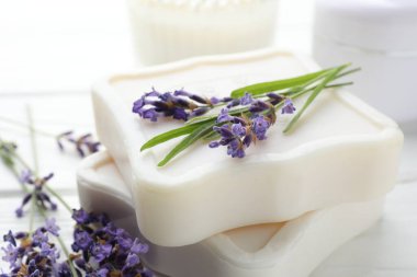 Sabun barları ve lavanta çiçekleri beyaz masada, yakın plan.