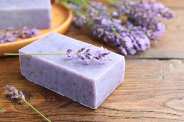 Sabun barı ve lavanta çiçekleri ahşap masada, yakın plan. Metin için boşluk