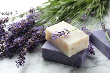 Sabun çubukları ve lavanta çiçekleri beyaz mermer masada, yakın plan.