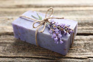 Aromatik sabun barı ve lavanta çiçekleri ahşap masada, yakın plan.