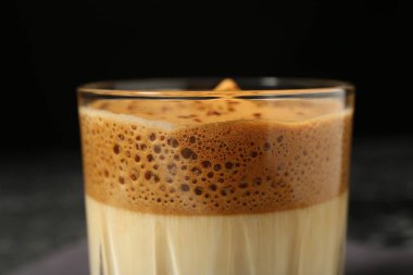 Bulanık arkaplanda bardakta lezzetli dalgona kahvesi, yakın plan.