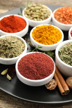 Ahşap masada farklı aromatik baharatlar, yakın plan.