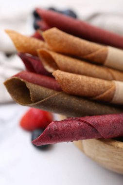 Lezzetli meyve dürümleri ve beyaz masada böğürtlenler, yakın plan.