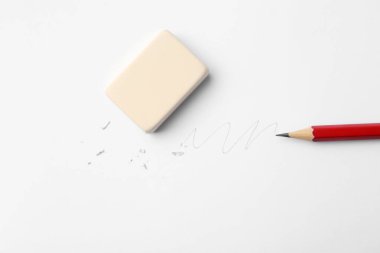 Beyaz arka planda kalem, silgi, karalama ve kırıntılar, düz uzanma