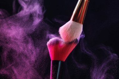 Siyah arkaplanda renk farlı makyaj fırçaları, yakın plan