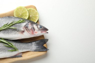 Beyaz masadaki baharatlı taze çiğ deniz kabuğu balığı, üst manzara ve yazı için yer. Deniz ürünleri lezzetleri.