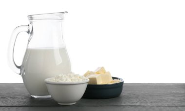 Gri ahşap masada beyaz arka planda farklı süt ürünleri