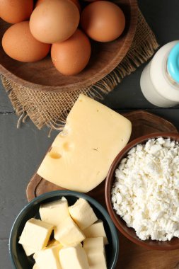 Farklı süt ürünleri ve yumurtalar gri ahşap masa üzerinde, düz yatıyordu.