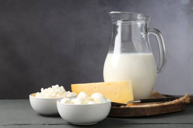 Gri ahşap masada farklı süt ürünleri