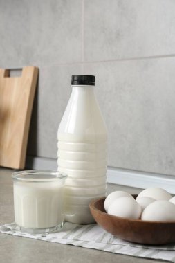 Mutfaktaki gri desenli masada süt ürünleri ve yumurtalar.