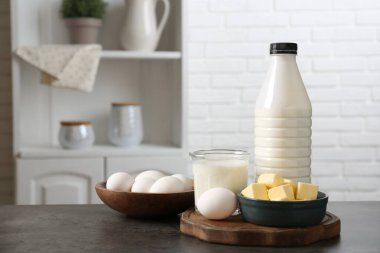 Mutfaktaki gri desenli masada farklı süt ürünleri ve yumurtalar.