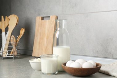 Mutfaktaki gri desenli masada farklı süt ürünleri ve yumurtalar.