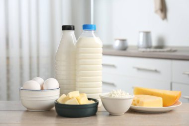 Mutfaktaki ahşap masada farklı süt ürünleri ve yumurtalar.