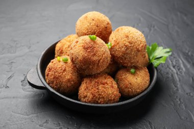 Maydanozlu ve yeşil soğanlı leziz kızarmış köfteler. Gri desenli masa, yakın plan.