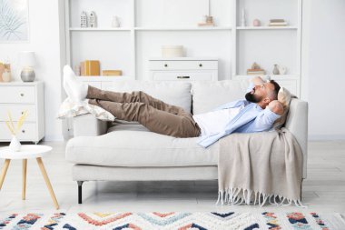 Uyum. Evdeki rahat koltukta dinlenen bir adam.