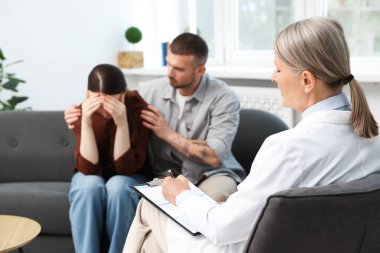 Tüp bebek (tüp bebek). Üreme kliniğinde doktorla görüşen üzgün çift.