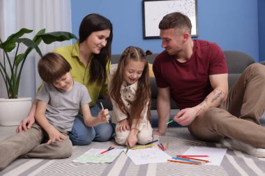 Ebeveynler çocuklarına evde yerde çizim yapmayı öğretiyor.