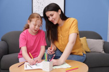 Anne kızına evde çizim yapmayı öğretiyor.