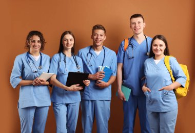 Kahverengi arka plan kitapları olan bir grup tıp öğrencisi.