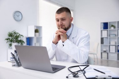 Klinikte bilgisayarla online danışmanlık yapan bir doktor