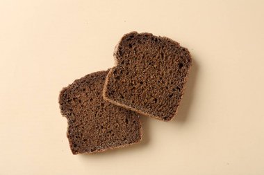 Bej arka planda taze çavdar ekmeği parçaları.