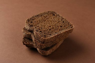 Kahverengi arka planda taze çavdar ekmeği parçaları, yakın plan.