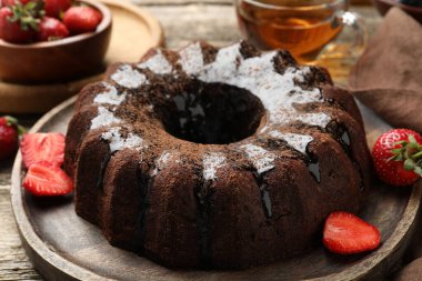 Lezzetli çikolatalı kek, cila, çay ve böğürtlen ahşap masada, yakın plan.