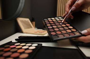 Makyaj masasında fırça ve göz falı olan kadın, yakın plan.