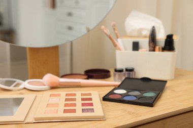 Farklı makyaj ürünleri ve kapalı mekandaki gösteriş fırçaları, yakın çekim