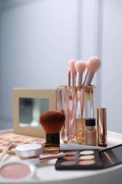 Beyaz masada farklı makyaj ürünleri, kapalı masa, yakın çekim.