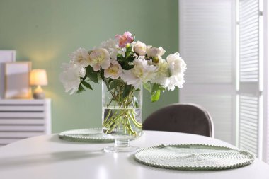 Yemek odasında bir vazo çiçekli güzel bir masa.