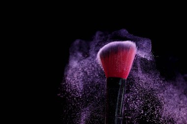 Siyah arka planda mor göz farlı makyaj fırçası, yakın plan. Metin için boşluk