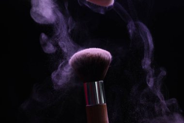 Siyah arka planda mor göz farlı makyaj fırçası, yakın plan
