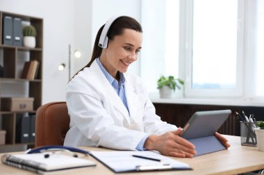 Kulaklık takan doktor kapalı alanda online danışmanlık yapıyor.