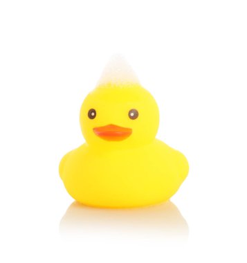 Aynada beyaz arka planda sevimli bir lastik ördek ve köpük.