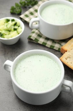 Gri masada servis edilen lezzetli salatalık çorbası, yakın plan.