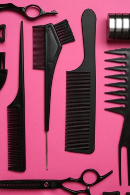 Pembe arka planda farklı kuaför aletleri, düz yatış