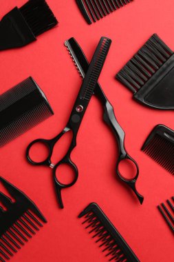 Kırmızı arka planda farklı kuaför aletleri, düz yatıyordu