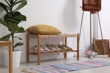 Koridordaki raflarda farklı ayakkabılar var.