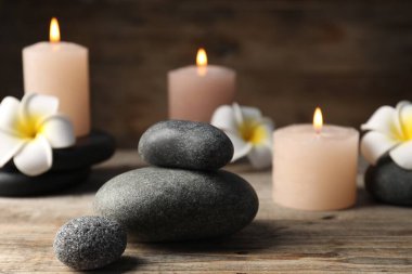 Tahta masanın üzerinde spa taşları olan kompozisyon, yakın plan.