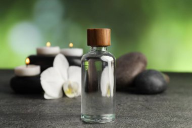 Gri masa üzerinde kozmetik ürünler ve spa taşlarıyla kompozisyon, yakın plan.