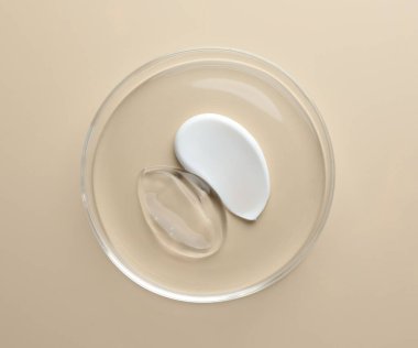 Petri kabında bej arka planda farklı kozmetik ürünleri, üst görünüm