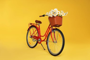 Sarı arka planda güzel çiçekli bisiklet sepeti